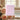 Pink Australian Bela pure natural soap bar in front of pink roses in luxury bath setting.