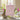 Pink bar of Bela soap in a bathroom setting with sweet pea and jasmine flowers in the background.
